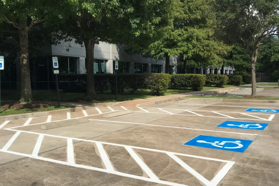 ADA-compliant accessible parking spaces with freshly painted striping, access aisles, and pavement markings at a commercial office property